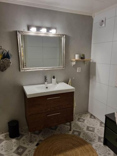 a bathroom with a sink and a mirror at Sokkel Leiligheten in Bøstad