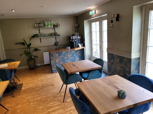 un restaurante con mesas de madera y sillas azules en Herberg De Eexter Os en Eext