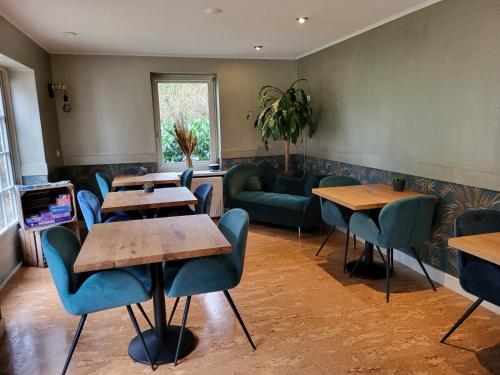 ein Restaurant mit Tischen und Stühlen und einer Couch in der Unterkunft Herberg De Eexter Os in Eext