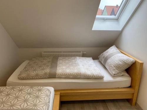 Bett in einem kleinen Zimmer mit Fenster in der Unterkunft Apartment Sonnenschein in Allersberg