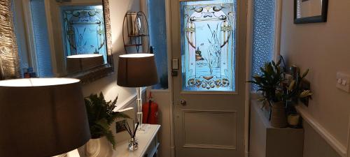 a hallway with a door with stained glass windows at Riverbank Guesthouse Inverness in Inverness