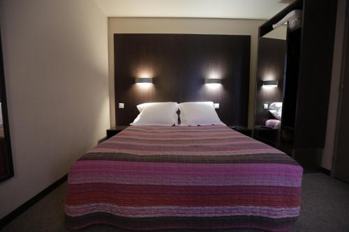 Postel nebo postele na pokoji v ubytování Hôtel Au Petit Caporal