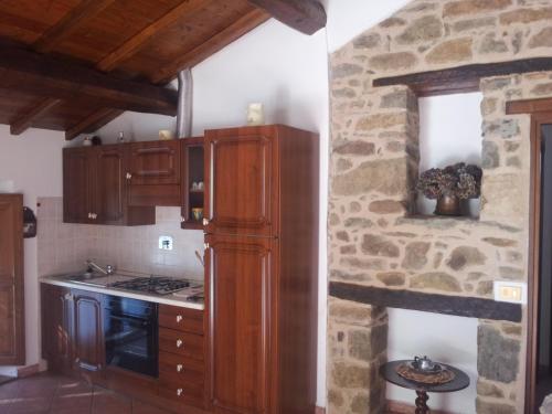 a kitchen with wooden cabinets and a stone wall at I 3 Porcellini in Cutigliano