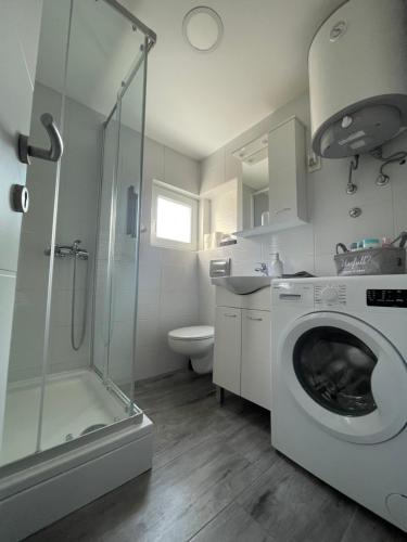 ein Bad mit einer Waschmaschine und einer Dusche in der Unterkunft Paradiseresidency in Zagreb