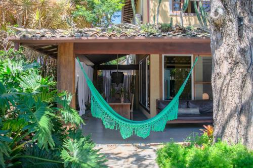 a hammock on a porch of a house at Pousada da Cyssa in Búzios