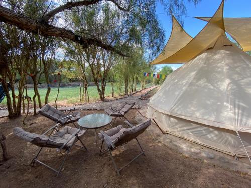 un gruppo di sedie, un tavolo e una tenda di CaminAndes Hostal a San Pedro de Atacama