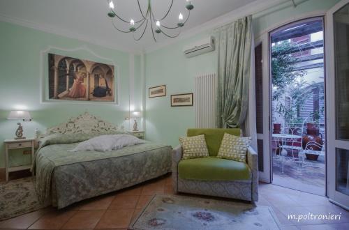 a bedroom with a bed and a chair and a window at Mondo Antico B&B in Cesena