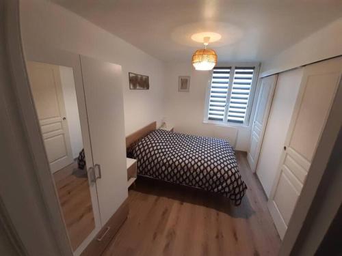 mała sypialnia z łóżkiem i oknem w obiekcie Appartement Le Michel-Ange w mieście Mers-les-Bains