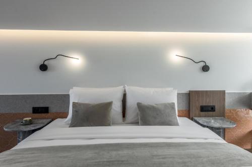a bedroom with a large white bed with two tables at ACRO Upscale Residences in Kórinthos