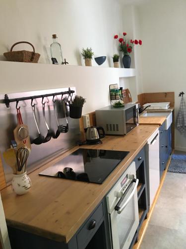 - une cuisine avec un comptoir en bois et des ustensiles dans l'établissement Grande Maison Village proche Verdon avec garage pour moto vélo, à Salernes