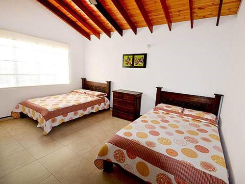 1 dormitorio con 2 camas y ventana en Cabañas Campestres Rincón de Apiay, en Apiay