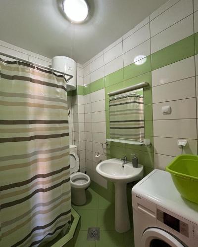 a green and white bathroom with a sink and a toilet at Apartments Montenegrina in Ulcinj