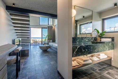 a bathroom with a large sink and a tub at ACRO Upscale Residences in Kórinthos