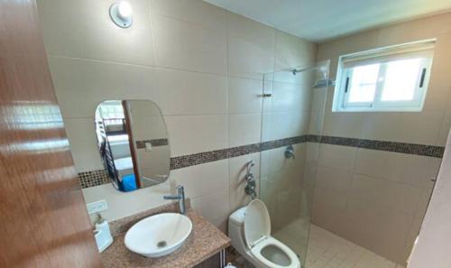 uma casa de banho com um WC, um lavatório e um espelho. em Hermosa Casa de Playa em Nueva Gorgona