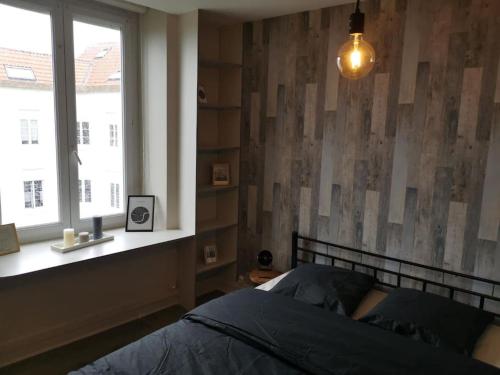 - une chambre avec un lit à côté d'une fenêtre dans l'établissement Petit nid sur la côte, à Boulogne-sur-Mer