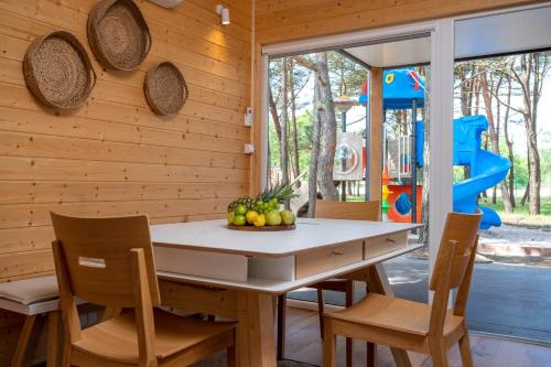 達洛瓦叩的住宿－Darłowo Beach Houses，一间带桌椅的用餐室和一个游乐场