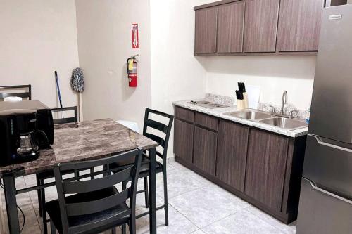 uma cozinha com um lavatório e uma mesa com cadeiras em Orsini Beach Apartment em Aguadilla