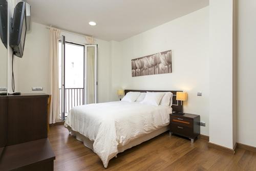 Säng eller sängar i ett rum på Apartments Center Madrid