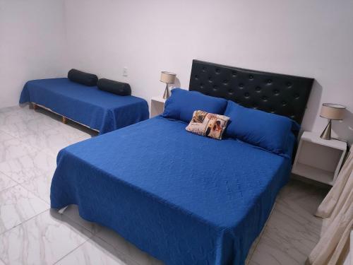 1 dormitorio con 2 camas y sábanas azules en Departamento con vista a Avenida Corrientes y la ciudad en Buenos Aires