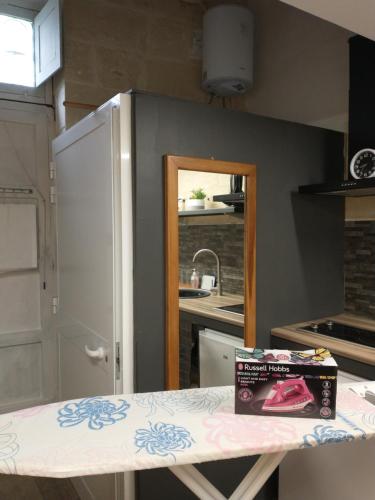 a kitchen with a counter and a box on a table at Cozy room in Birżebbuġa