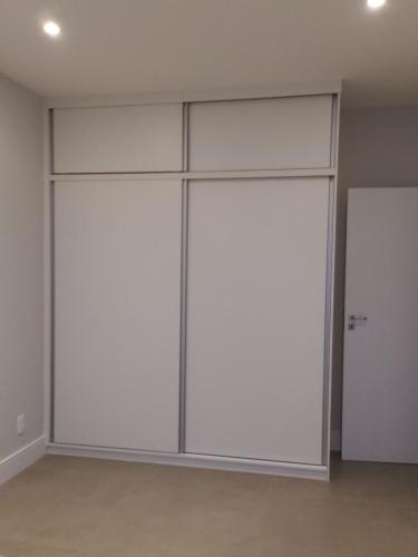 two large white closet doors in a room at Apartamento reformado, tudo novo, Copa-Ipanema in Rio de Janeiro