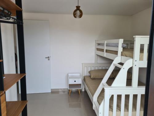 a bunk bed in a small room with a ladder at Apartamento novo em Caiobá in Matinhos