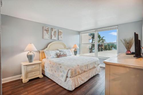 a bedroom with a bed and a large window at Madeira Vista 201 in St. Pete Beach
