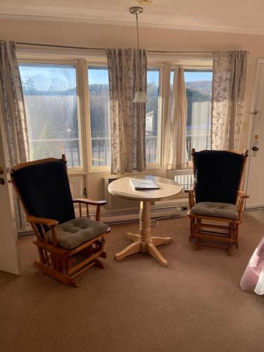 a living room with two chairs and a table and a window at Cliff Dwellers Inn in Blowing Rock