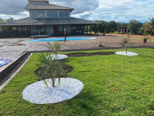 un patio con dos palmeras en el césped en Casa de campo completa! Chácara Magnífica!, en Caldas Novas
