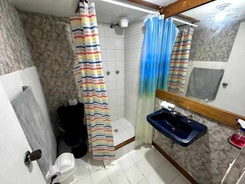 y baño con cortina de ducha y lavamanos. en ApartaStudio El Poblado, en Medellín