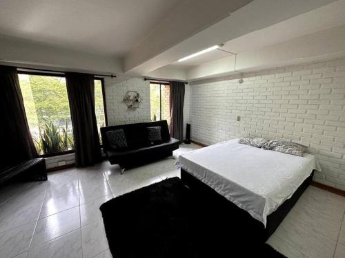 een slaapkamer met een bed en een bank erin bij ApartaStudio El Poblado in Medellín