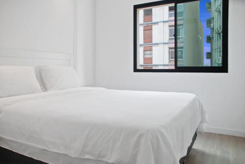 1 dormitorio con cama blanca y ventana en Hotel Luxuoso na Paulista, en São Paulo