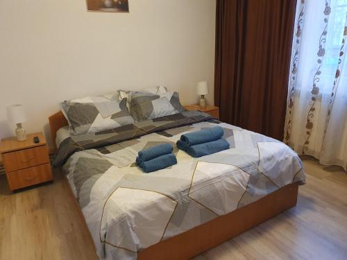 a bedroom with a bed with blue pillows on it at ZSE Residence in Constanţa