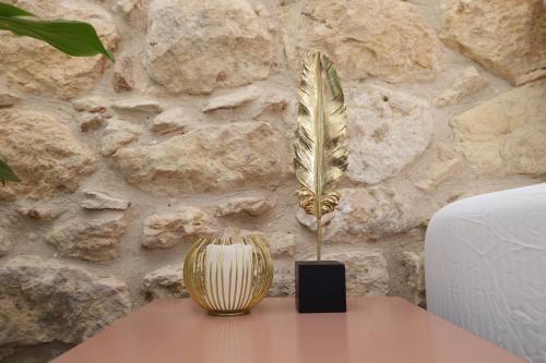 a feather vase on a table next to a stone wall at Helios Boutique by La Finca Hotels in Beer Sheva
