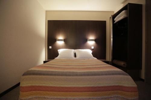Postel nebo postele na pokoji v ubytování Hôtel Au Petit Caporal