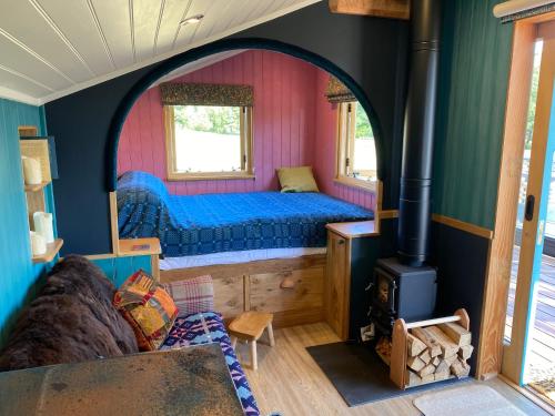 um quarto com uma cama e um fogão em Dôl Swynol Glamping Luxury cabin with outdoor bath em Aberystwyth