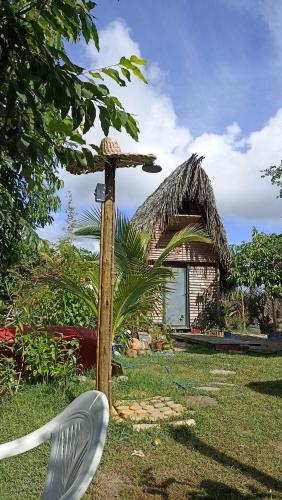 a chair in front of a house with a straw roof at Flor da Aldeia Eco Hospedaria in Camaçari