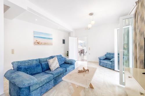 a living room with a blue couch and a table at 4You Luxury Apartments by Keyplanner in Moraitika