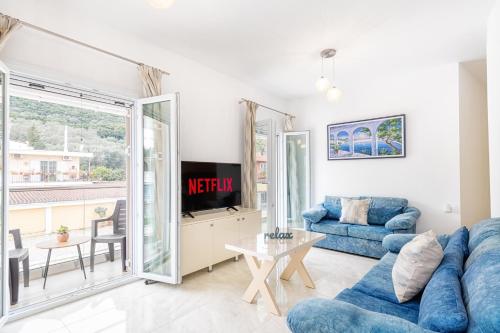 4You Luxury Apartments by Keyplanner في مورايتيكا: غرفة معيشة مع أريكة زرقاء وطاولة