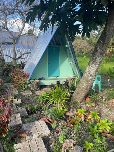 a tiny house with a roof in a garden at House of TamSe Laagans ' Inn in Badian