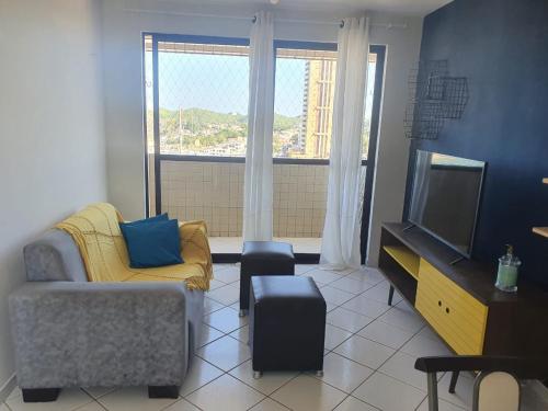 sala de estar con sofá y TV en Apartamentos Natal, en Natal