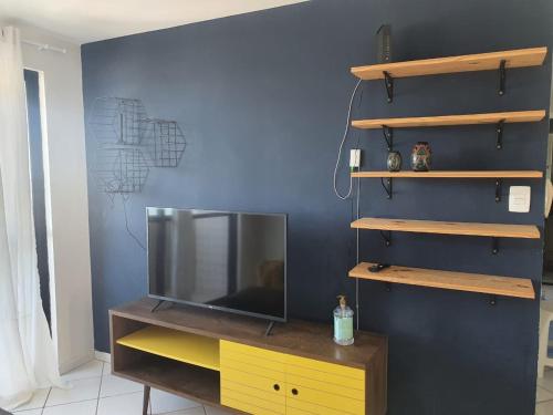 un televisor sentado en un tocador en una habitación en Apartamentos Natal, en Natal