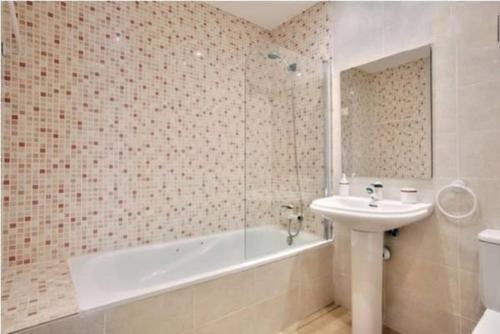 ein Badezimmer mit einer Badewanne, einem Waschbecken und einer Badewanne in der Unterkunft Apartment Ronda City Center in Ronda