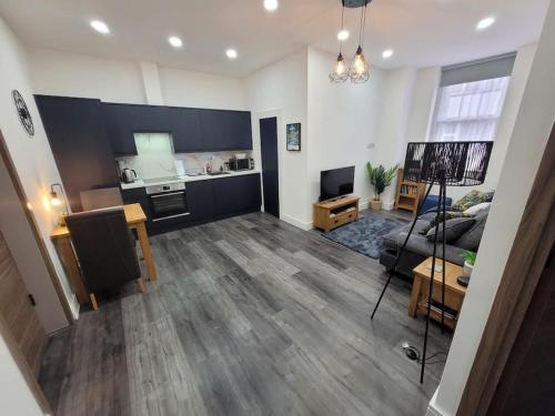 a living room with a couch and a kitchen at Contemporary 1 Bed Apartment, In Central Buxton in Buxton