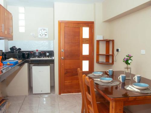 a kitchen with a wooden table and a wooden door at Casa Itabaca II in Puerto Ayora