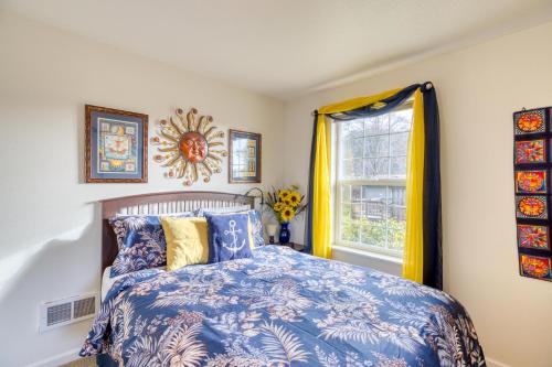a bedroom with a blue and white bed and a window at Rockaway Retreat in Rockaway Beach