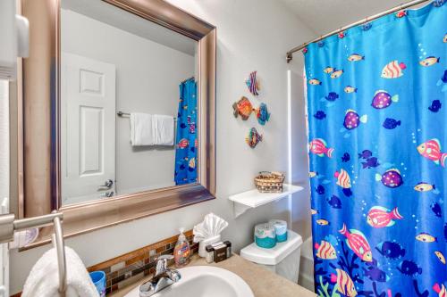 a bathroom with a blue shower curtain and a sink at Rockaway Retreat in Rockaway Beach