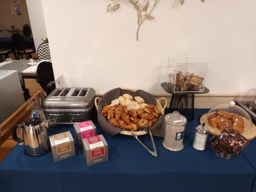a table with a bowl of food and a basket of pastries at DOMITYS Résidence services seniors LE PARC DES AUBIERS in Poissy