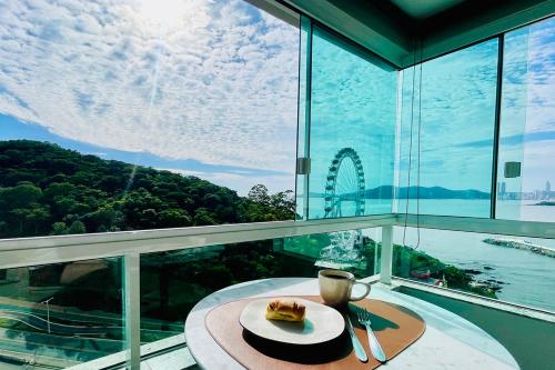 una mesa con un plato de comida y una taza de café en Studio de frente para o mar em Balneário Camboriú, en Balneário Camboriú