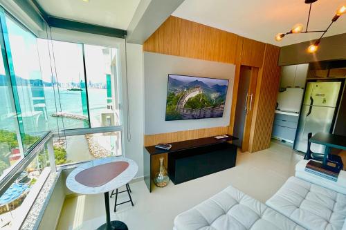 a living room with a white couch and a window at Studio de frente para o mar em Balneário Camboriú in Balneário Camboriú